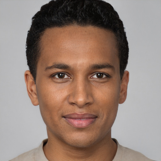 Joyful black young-adult male with short  black hair and brown eyes