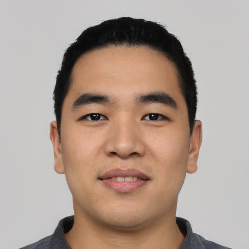 Joyful asian young-adult male with short  black hair and brown eyes