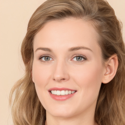 Joyful white young-adult female with long  brown hair and blue eyes