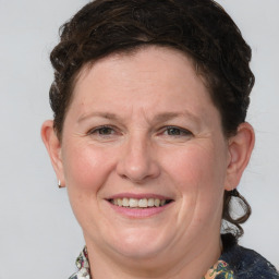 Joyful white adult female with medium  brown hair and blue eyes