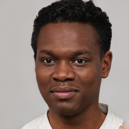 Joyful black young-adult male with short  black hair and brown eyes