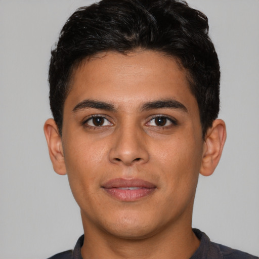 Joyful latino young-adult male with short  brown hair and brown eyes