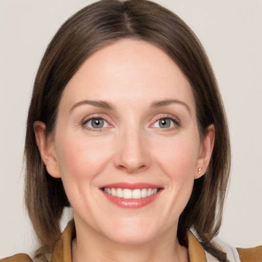 Joyful white young-adult female with medium  brown hair and grey eyes