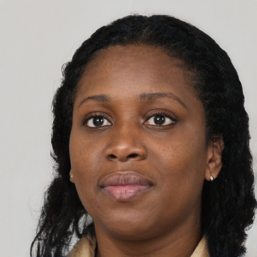 Joyful black young-adult female with long  black hair and brown eyes