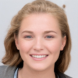 Joyful white young-adult female with long  brown hair and blue eyes