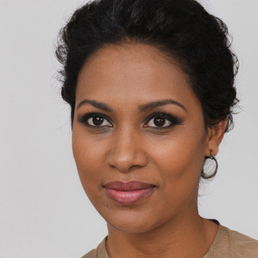 Joyful black young-adult female with short  black hair and brown eyes