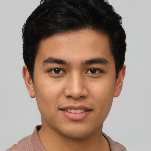 Joyful latino young-adult male with short  brown hair and brown eyes