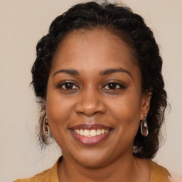 Joyful black young-adult female with long  brown hair and brown eyes