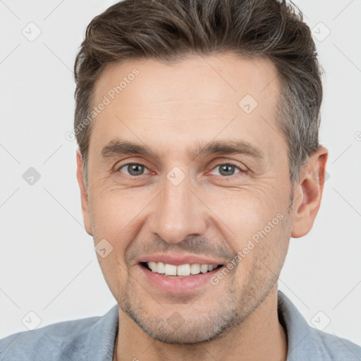 Joyful white adult male with short  brown hair and brown eyes