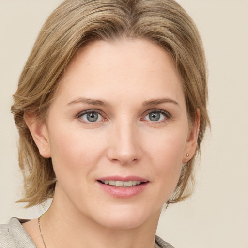 Joyful white young-adult female with medium  brown hair and blue eyes