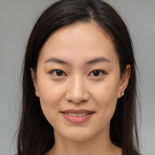 Joyful asian young-adult female with long  brown hair and brown eyes