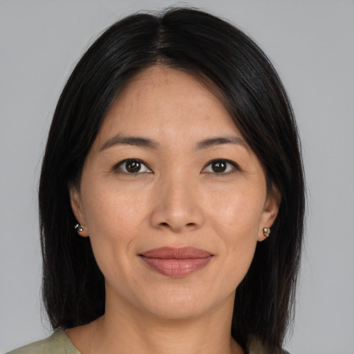 Joyful asian young-adult female with long  brown hair and brown eyes