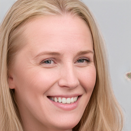 Joyful white young-adult female with long  brown hair and blue eyes