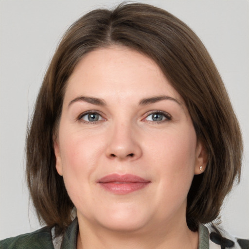 Joyful white adult female with medium  brown hair and grey eyes