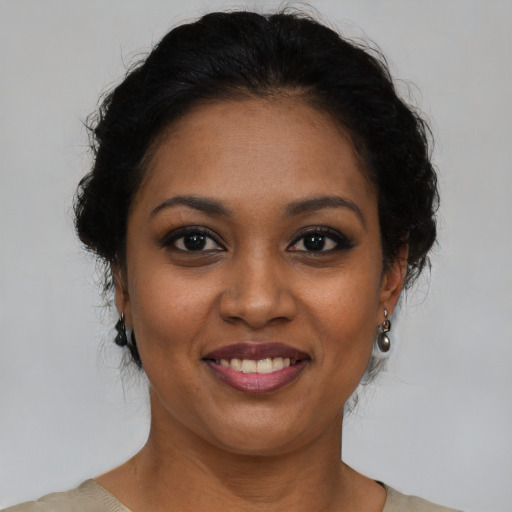 Joyful black young-adult female with medium  brown hair and brown eyes
