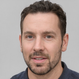 Joyful white adult male with short  brown hair and grey eyes