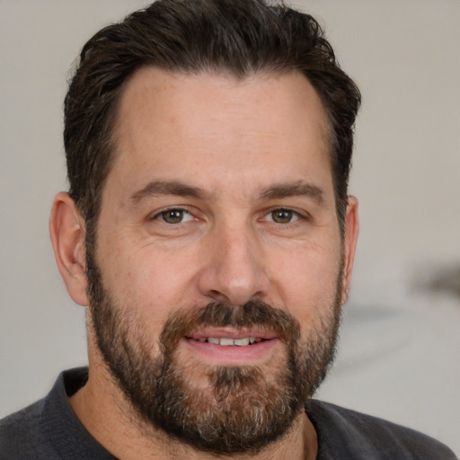 Joyful white adult male with short  brown hair and brown eyes