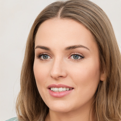 Joyful white young-adult female with long  brown hair and green eyes