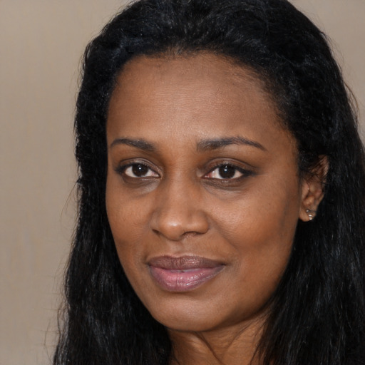 Joyful black young-adult female with long  black hair and brown eyes