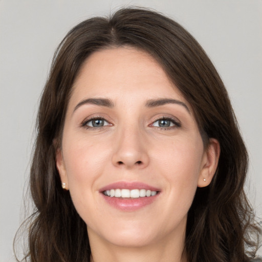 Joyful white young-adult female with long  brown hair and grey eyes