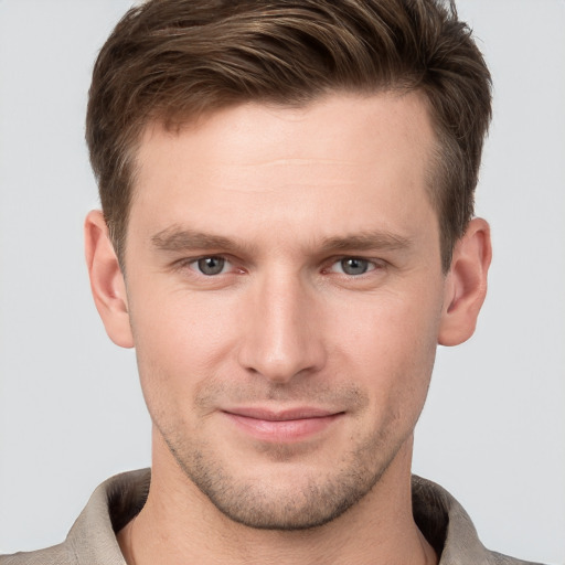 Joyful white young-adult male with short  brown hair and grey eyes