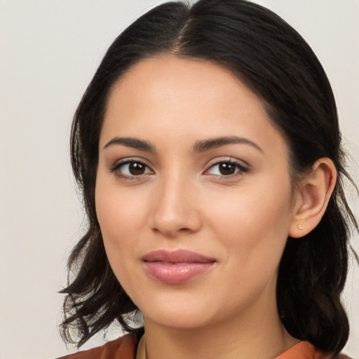 Joyful latino young-adult female with medium  brown hair and brown eyes