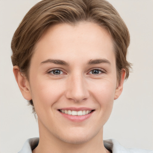 Joyful white young-adult female with short  brown hair and grey eyes