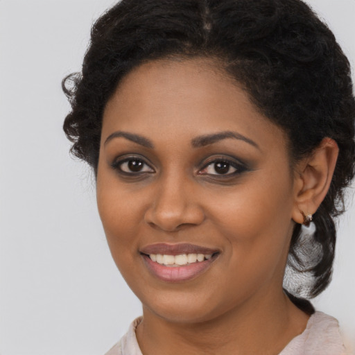 Joyful black young-adult female with long  brown hair and brown eyes
