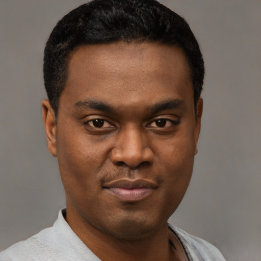 Joyful black young-adult male with short  brown hair and brown eyes