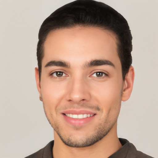 Joyful white young-adult male with short  black hair and brown eyes