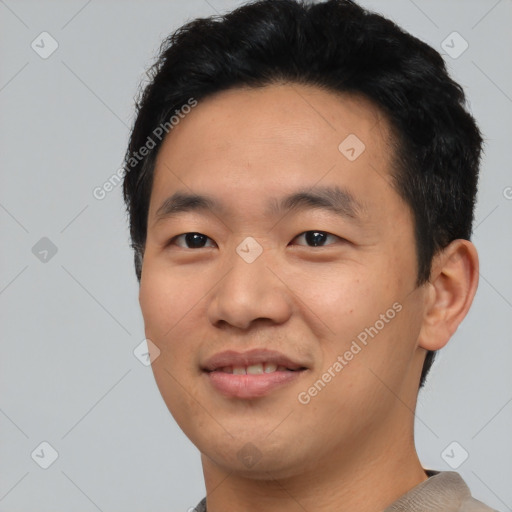 Joyful asian young-adult male with short  black hair and brown eyes