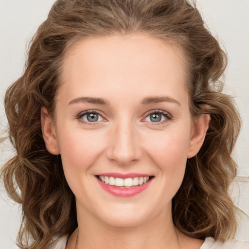 Joyful white young-adult female with long  brown hair and green eyes