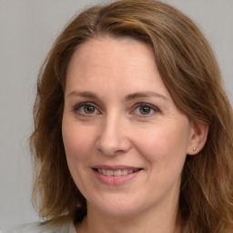 Joyful white adult female with medium  brown hair and grey eyes