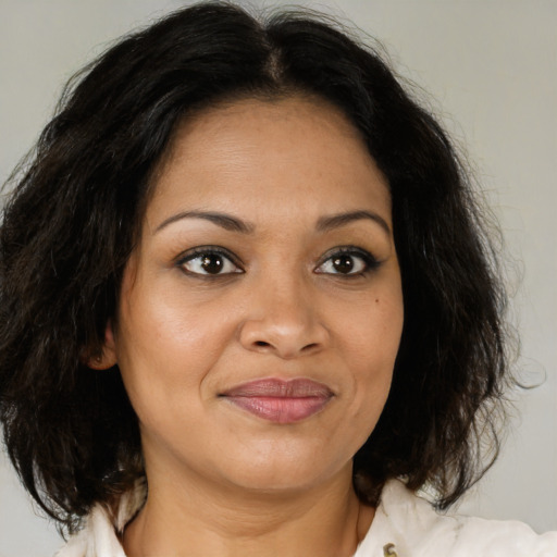 Joyful latino adult female with medium  brown hair and brown eyes