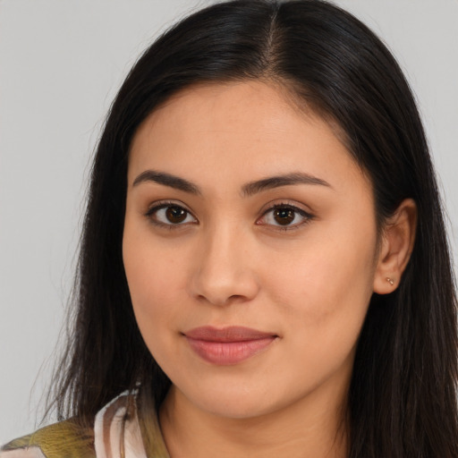 Joyful latino young-adult female with long  brown hair and brown eyes
