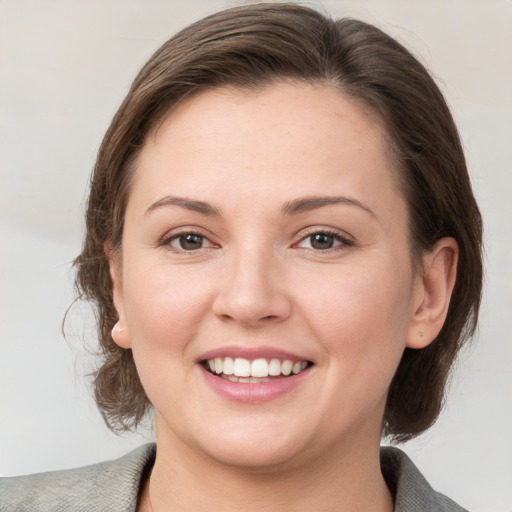 Joyful white young-adult female with medium  brown hair and grey eyes