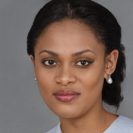 Joyful black young-adult female with medium  black hair and brown eyes