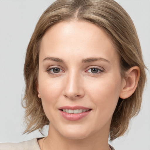 Joyful white young-adult female with medium  brown hair and grey eyes