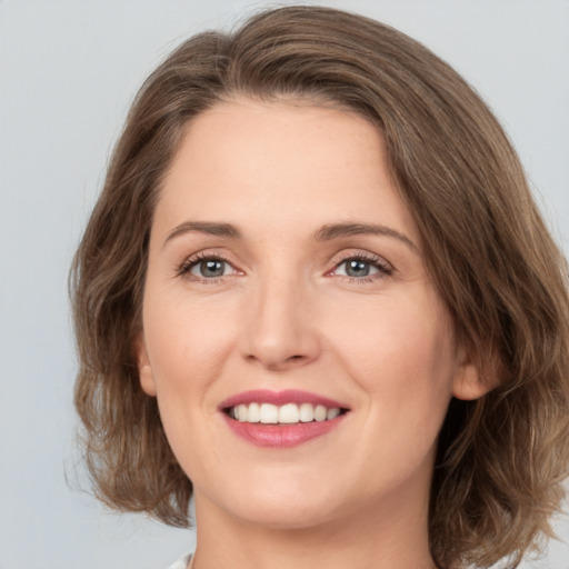 Joyful white young-adult female with medium  brown hair and green eyes