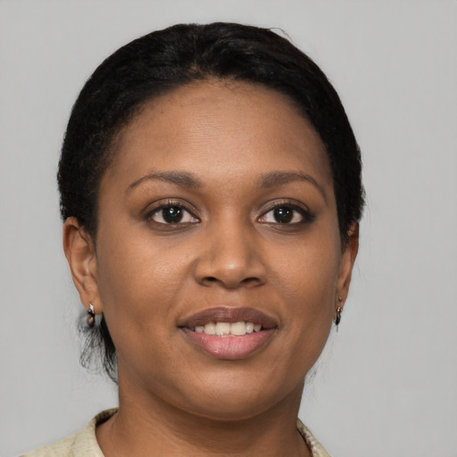Joyful black young-adult female with short  black hair and brown eyes
