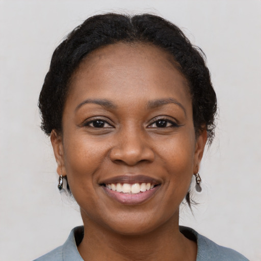 Joyful black young-adult female with medium  brown hair and brown eyes