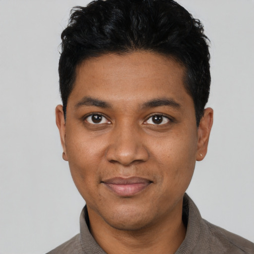 Joyful black young-adult male with short  black hair and brown eyes