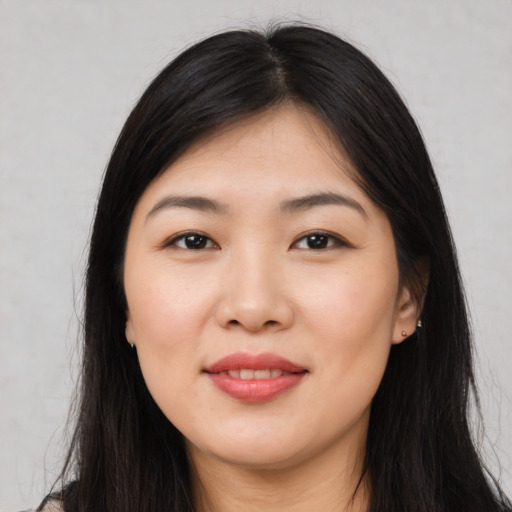 Joyful asian young-adult female with long  brown hair and brown eyes