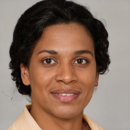 Joyful latino adult female with medium  brown hair and brown eyes