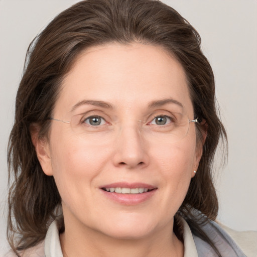 Joyful white adult female with medium  brown hair and grey eyes