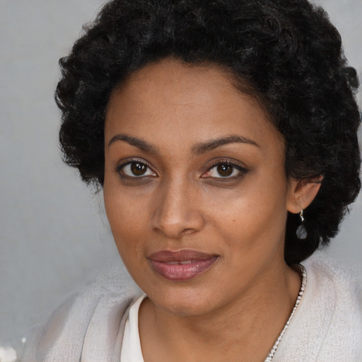 Joyful black young-adult female with short  black hair and brown eyes