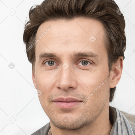 Joyful white young-adult male with short  brown hair and grey eyes