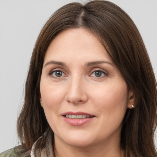 Joyful white young-adult female with medium  brown hair and grey eyes