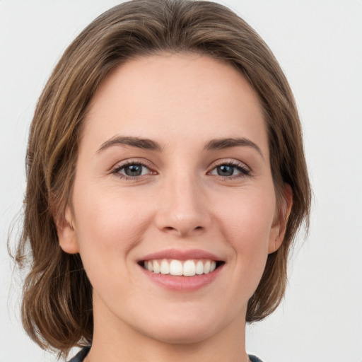 Joyful white young-adult female with medium  brown hair and green eyes