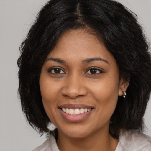 Joyful black young-adult female with medium  brown hair and brown eyes